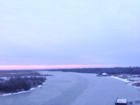 1979 Ford Bronco - Frozen river landscape at dusk with snow on the banks and a faint pink horizon.