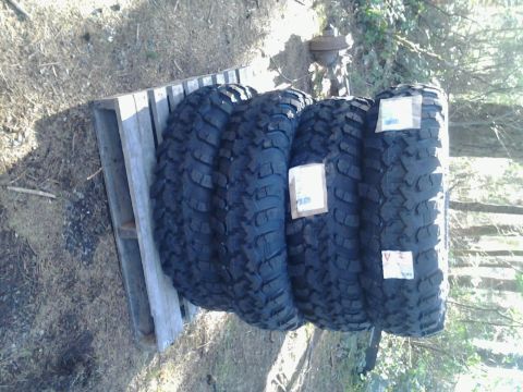 1971 Ford F-250 - Four off-road tires are stacked on a wooden pallet, ready for installation.