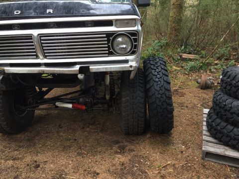 1971 Ford F-250 - Front view of a black 1973 Ford F-Series truck with a chrome grille and large tires, parked outdoors.