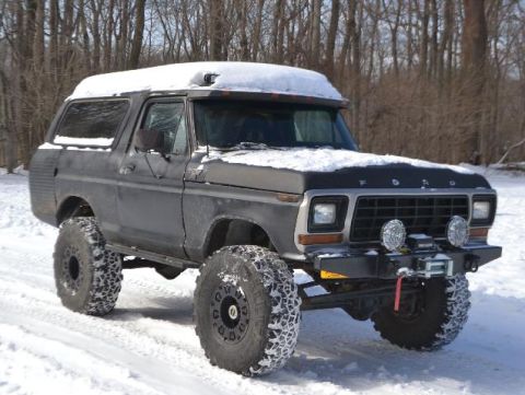 1979 Ford Bronco - A lifted Ford Bronco sits in a snowy landscape, ready for off-road adventure.