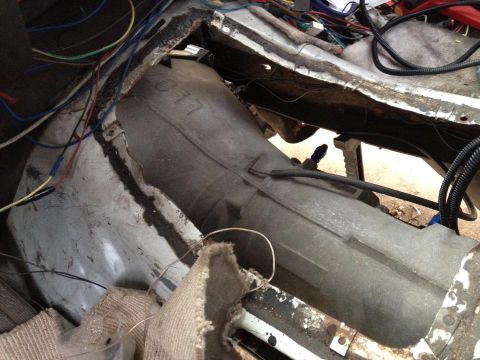 1989 Ford Bronco - The interior of a vehicle is shown with exposed wiring and the transmission tunnel.