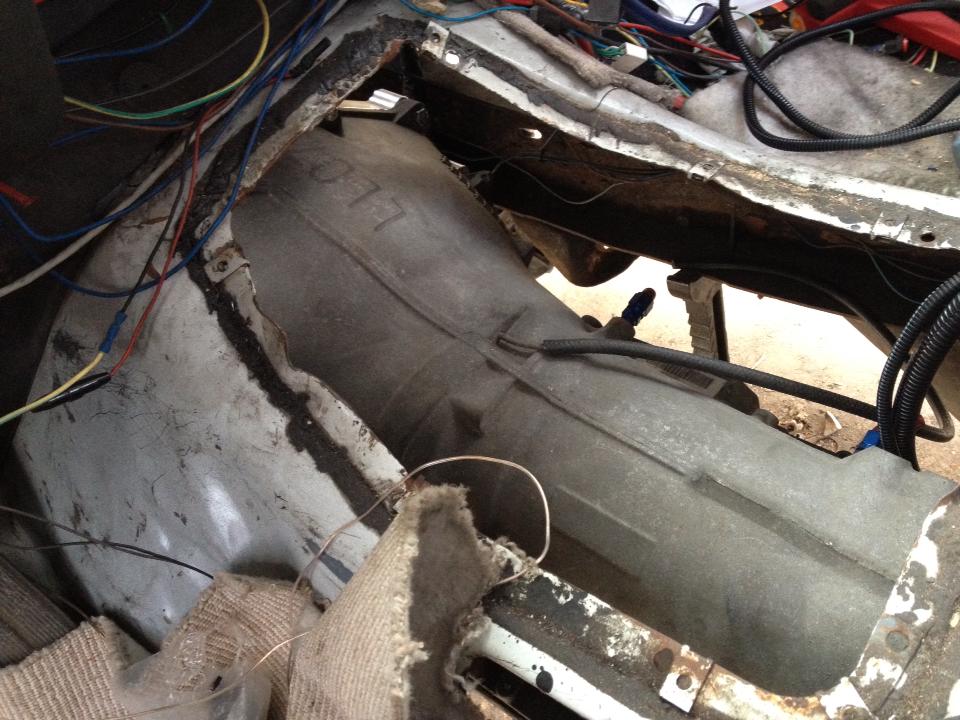 Underneath the carpet, showing the transmission tunnel and lots of wiring