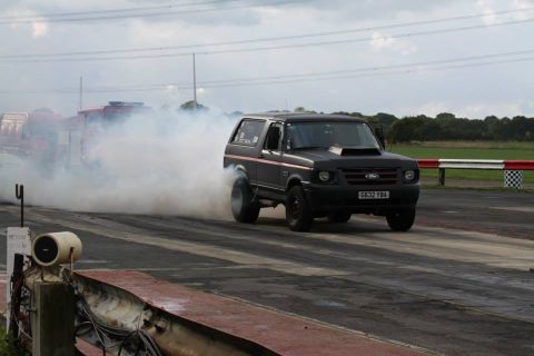 1989 Ford Bronco - A modified Ford Bronco performs a burnout on a drag strip, kicking up a large cloud of smoke.