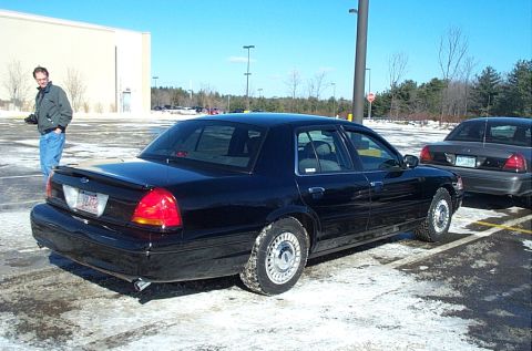 1991 Ford LTD Crown Victoria - A black sedan is parked in a lot with snow on the ground, with another car behind it.