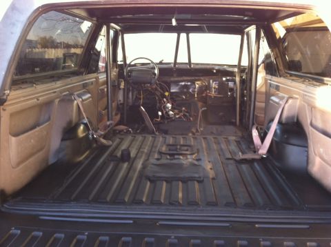 1995 Ford Bronco - The interior of the vehicle has been stripped down, revealing the floor, roll cage, and exposed wiring.