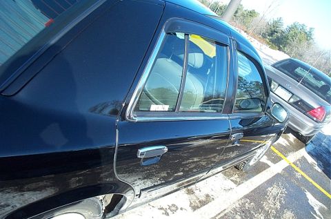1991 Ford LTD Crown Victoria - Side profile of a black sedan with chrome accents and a second vehicle visible in the background.