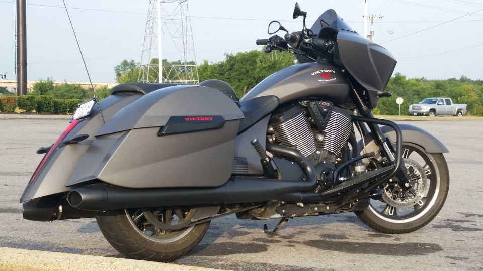 Gray Victory motorcycle with saddlebags and a black engine guard, viewed from the right