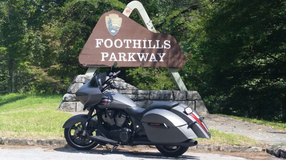 Gray Victory motorcycle parked by a 'Foothills Parkway' sign