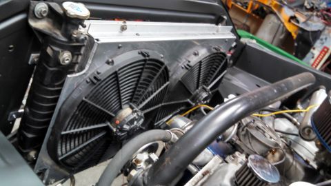 1967 Ford F-250 - Close-up of an engine bay a radiator and dual electric cooling fans.