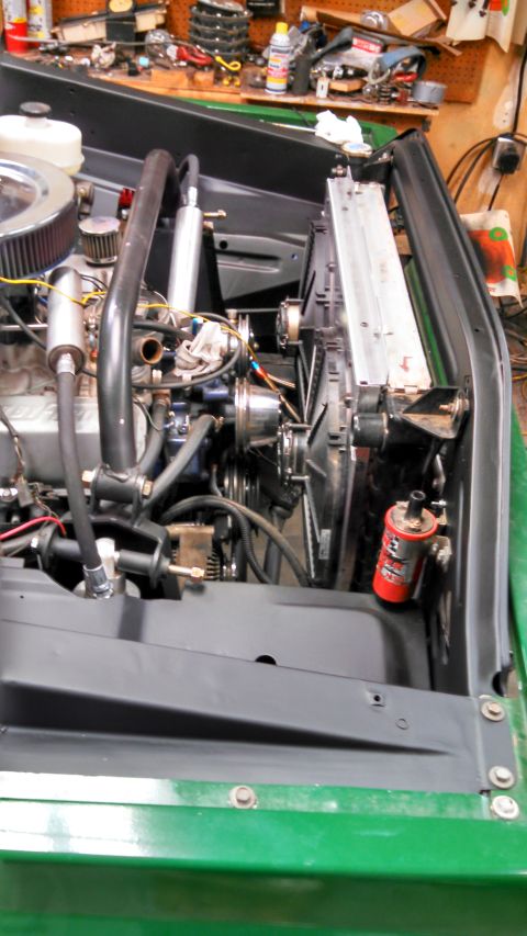 1967 Ford F-250 - Close-up view of the engine bay of a green truck, showing the radiator and fan assembly.