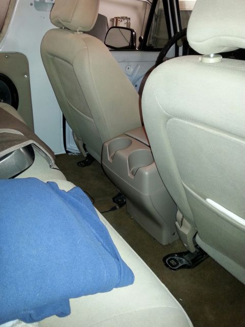 1979 Ford Bronco - Interior view of a car showing tan seats, a center console, and a blue blanket.