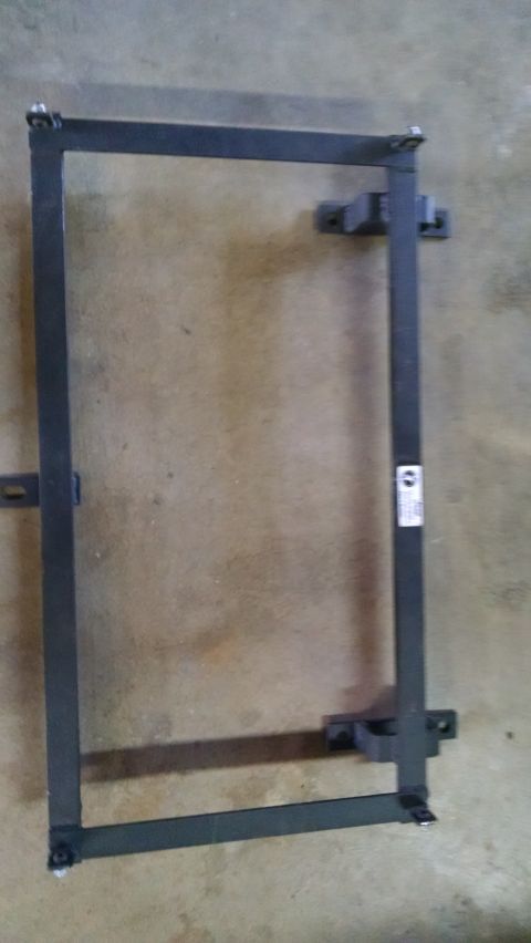 1985 Jeep CJ7 - A metal frame with mounting brackets is shown against a concrete floor.
