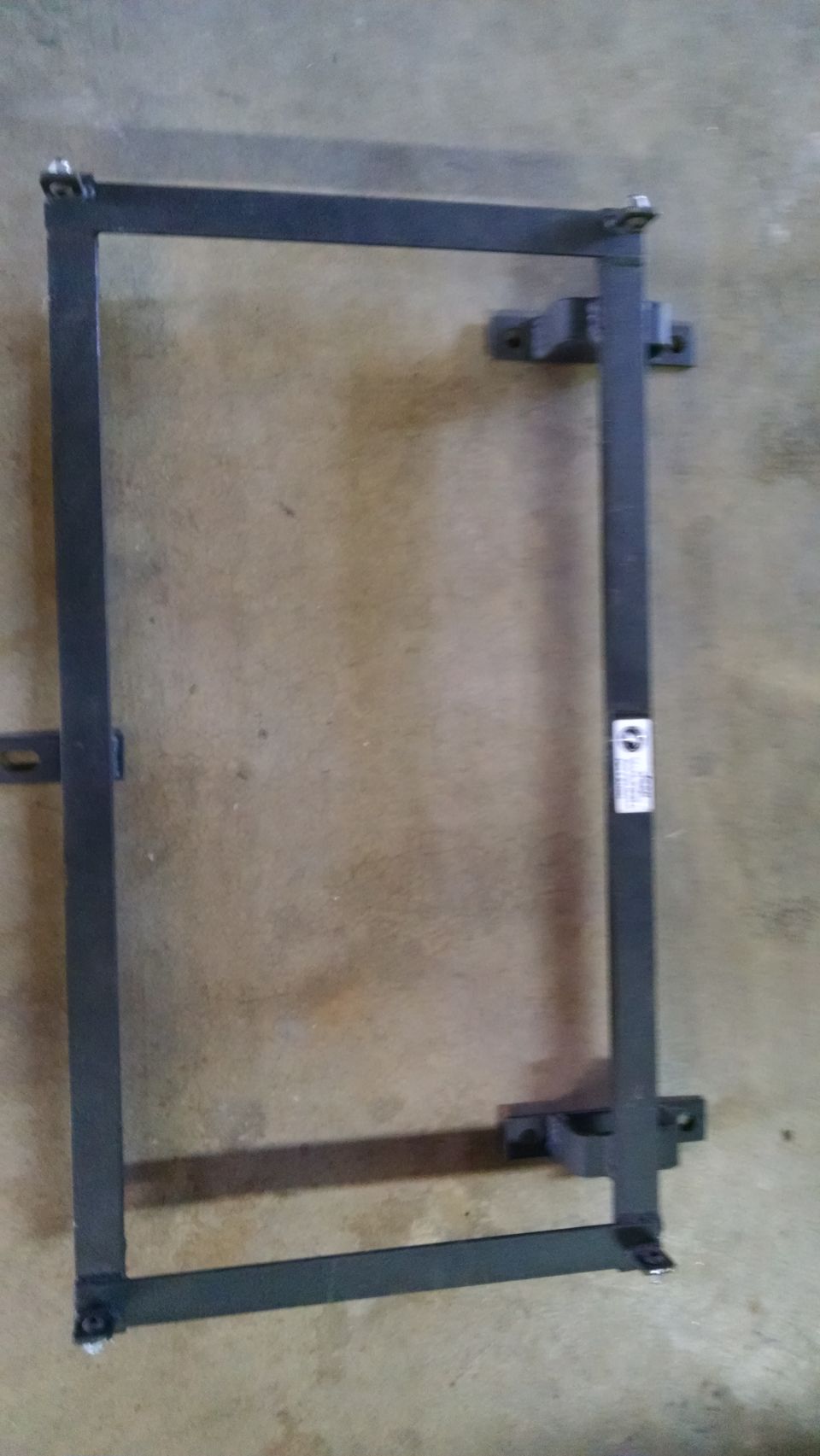 metal frame with mounting brackets, possibly for a seat or battery
