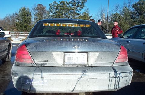 1991 Ford LTD Crown Victoria - This Ford Crown Victoria Police Interceptor has a light bar mounted inside the rear window and a "Buckle Up" sticker on the bumper.