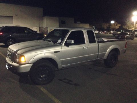 1992 Ford F-150 - A silver Ford Ranger pickup truck is parked in a lot at night, with another vehicle nearby.