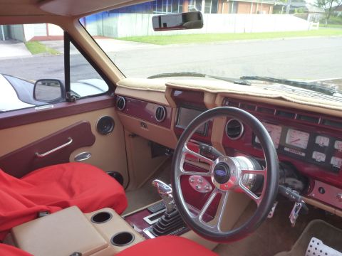 1985 Ford Bronco - Interior view of a 1985 Ford Bronco, custom steering wheel and red seat covers.
