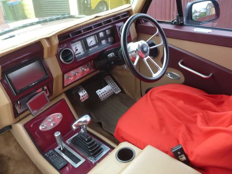 1985 Ford Bronco - The interior features a custom steering wheel, updated gauges, and a floor shifter, suggesting significant modifications.