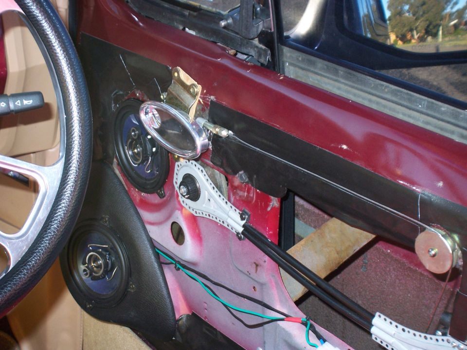 Interior of a car door with speakers and window regulator mechanism visible