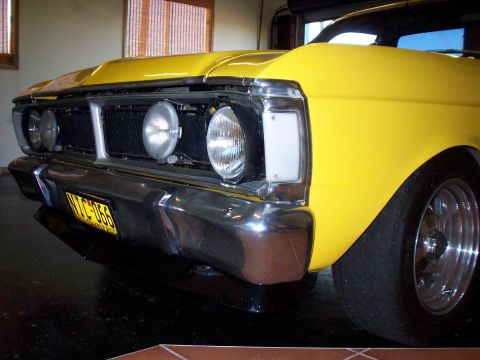 1985 Ford Bronco - Front view of a yellow car, likely from the early 1970s, with a prominent grille and bumper.