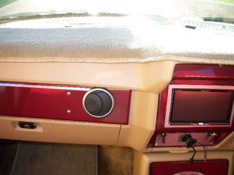 1985 Ford Bronco - Interior view of a dashboard an aftermarket stereo system and custom red trim accents.
