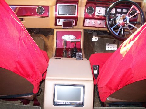 1985 Ford Bronco - Customized interior features multiple screens and a unique center console setup.