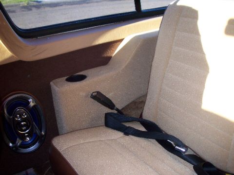 1985 Ford Bronco - Interior view of a vehicle showing seats, a console, and a speaker.