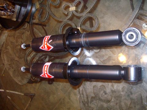 2004 Ford Crown Victoria - Pair of shock absorbers, possibly for a car, resting on a table.