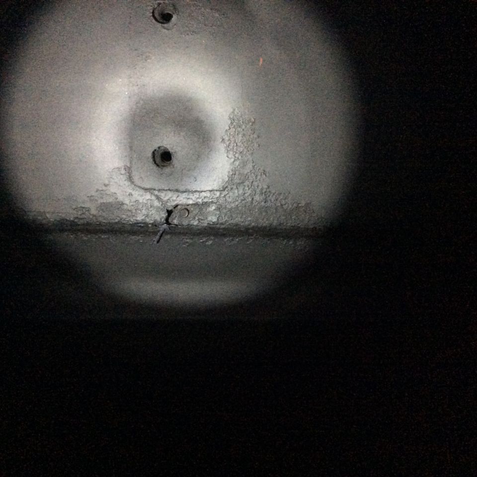 Underside of vehicle with two bolts and a wire. Supermotors.net text visible