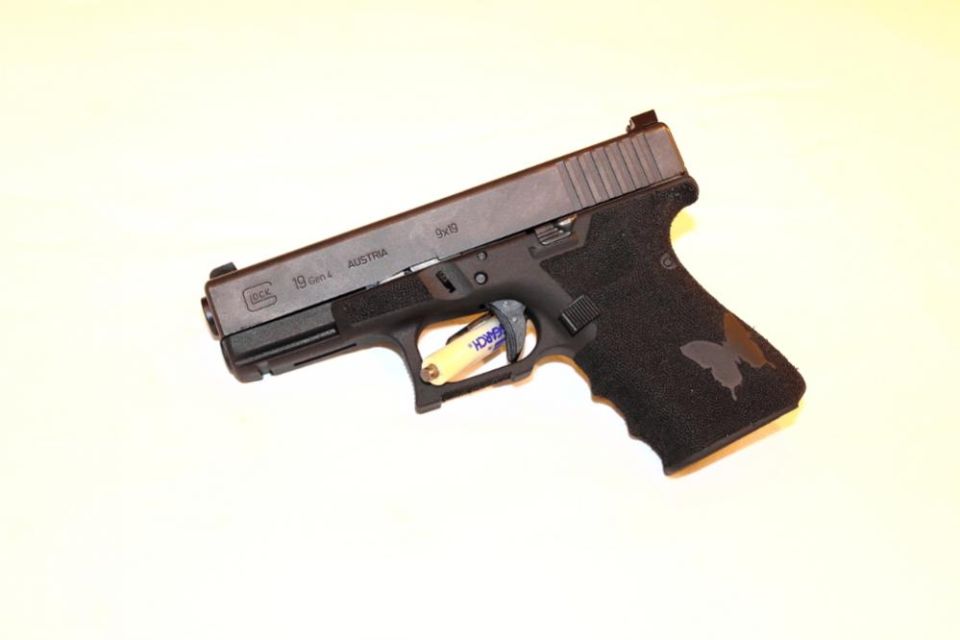 Glock 19 Gen 4 pistol with butterfly decal on grip