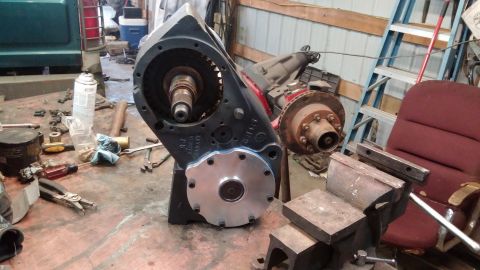 1995 Ford Bronco - A disassembled NP205 transfer case with a PTO adapter plate is shown on a workbench, with tools scattered around.