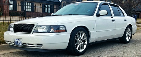 White sedan with a black grille and Nevada license plate, viewed from the front three-quarter angle
