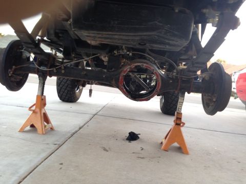 1987 Suzuki Samurai - The rear axle assembly of a vehicle is elevated on jack stands for maintenance or repair.