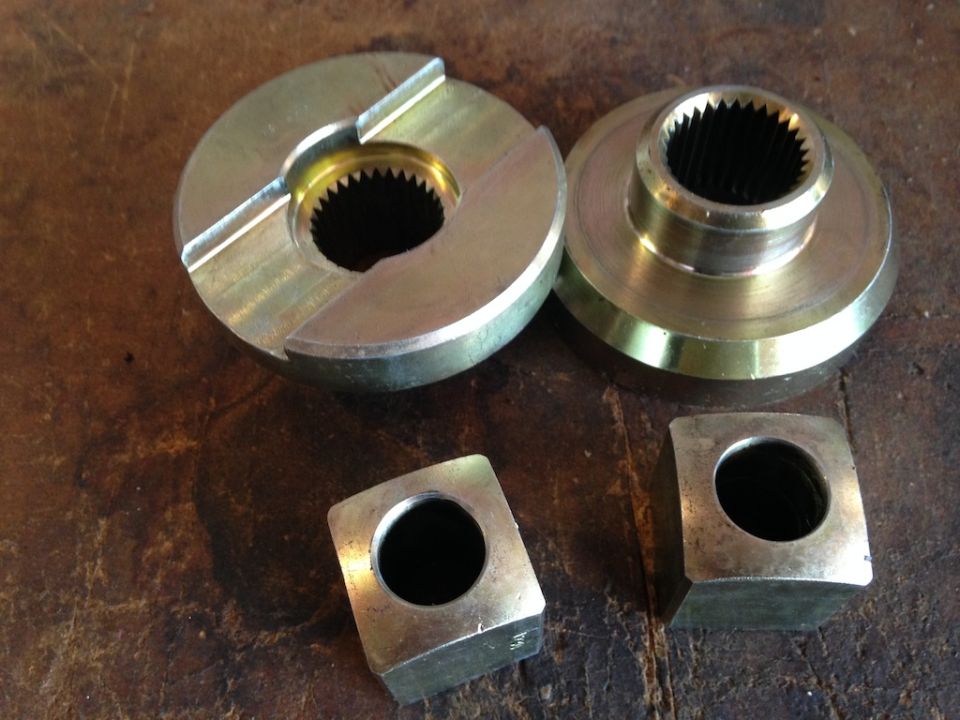 Two differential gears and two square blocks with holes on a wooden surface. Supermotors.net logo visible