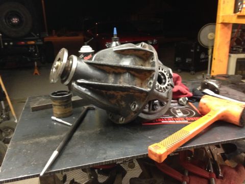 1987 Suzuki Samurai - A differential housing sits on a workbench with a rubber mallet and pry bar nearby.