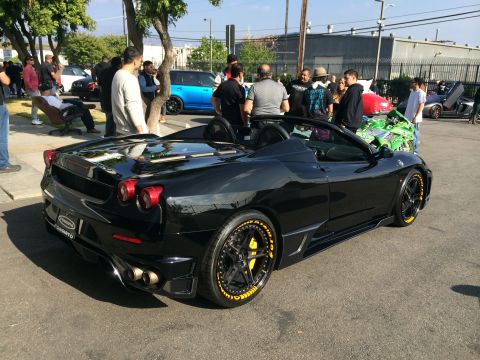 1968 Ford Mustang - A black convertible sports car with yellow accents is parked at an outdoor event.