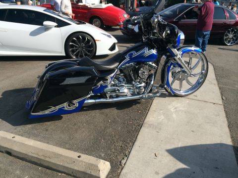 1968 Ford Mustang - A custom motorcycle with elaborate blue and silver graphics is displayed alongside other vehicles.