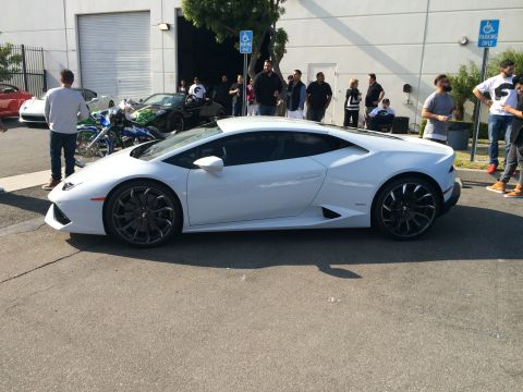 1968 Ford Mustang - A white Lamborghini Huracan is parked outside a building with several people standing around.
