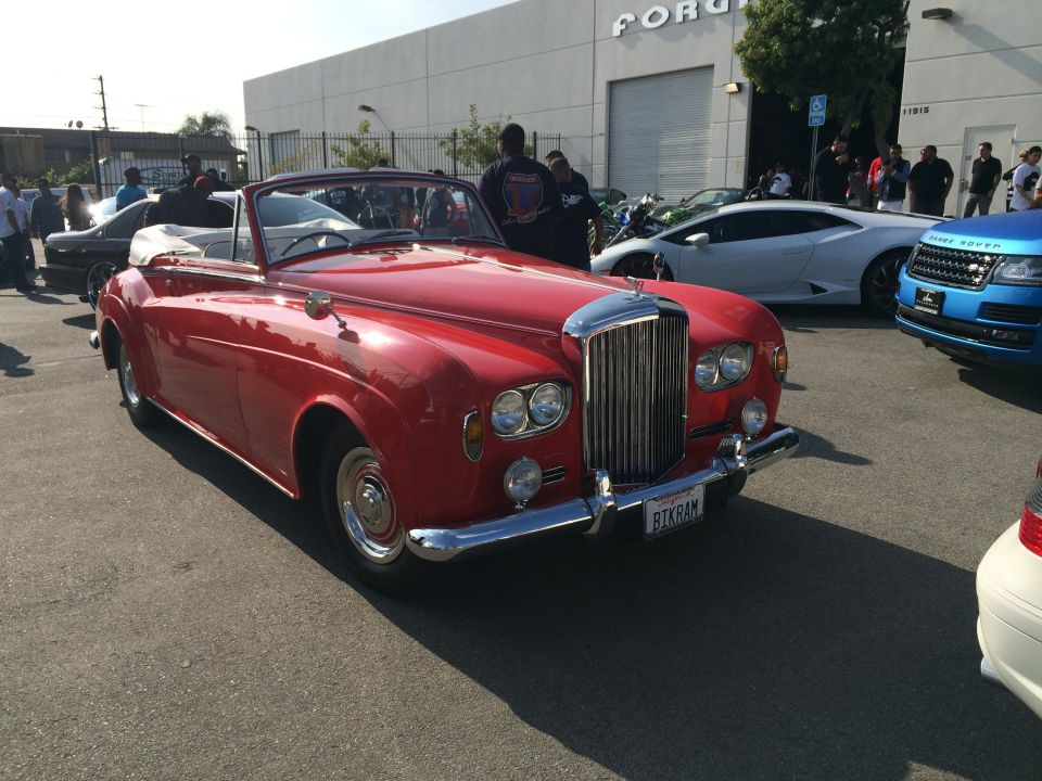 Red convertible Bentley with chrome grille and license plate BIKRAM