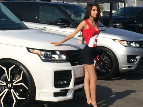 1968 Ford Mustang - Woman poses with two Range Rover SUVs at an outdoor event.