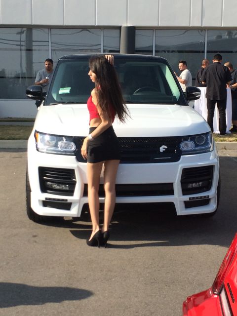 1968 Ford Mustang - A woman poses next to a white Range Rover at an outdoor event.