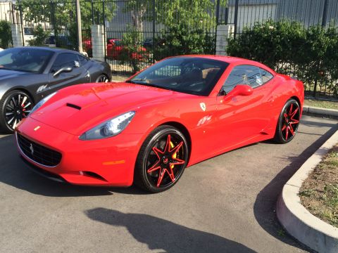 1968 Ford Mustang - A red Ferrari California is parked next to a grey car, both with custom wheels.