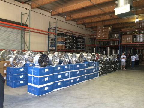 1968 Ford Mustang - A warehouse stocked with various car wheels, neatly organized on top of blue storage boxes.