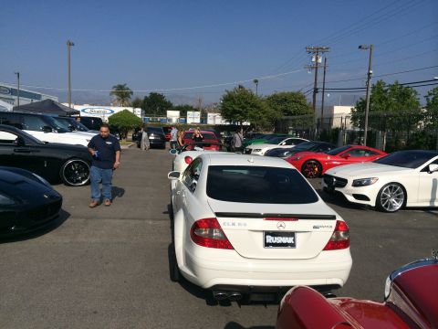 1968 Ford Mustang - A gathering of cars in a parking lot, a white Mercedes CLK 63 AMG prominently in the foreground.