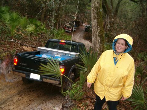 1991 Ford Bronco - A group of trucks navigate a muddy trail through a wooded area.