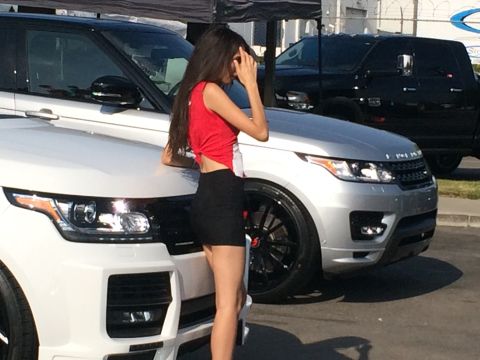 1968 Ford Mustang - A woman poses next to a white Range Rover, with another silver Range Rover visible in the background.