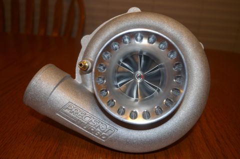 2007 Mazda 6 - A close-up of a Precision Turbocharger sits on a wooden surface.