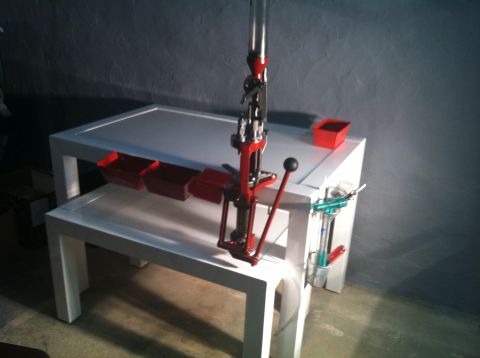 1992 Ford Mustang - A reloading press is set up on a table with several red bins for holding components.