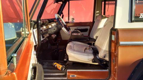 1985 Jeep CJ7 - Interior of a vintage SUV with worn seats and dashboard. A can of spray paint is visible on the floor.