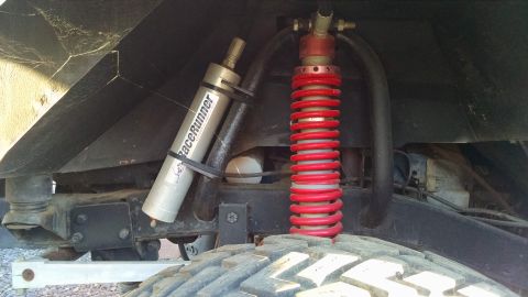 1985 Jeep CJ7 - The vehicle's suspension features a RaceRunner shock absorber and a red coilover shock, indicating off-road modifications.