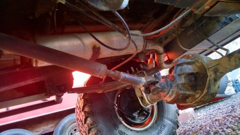 1985 Jeep CJ7 - Undercarriage detail of a vehicle, focusing on suspension and drivetrain components.